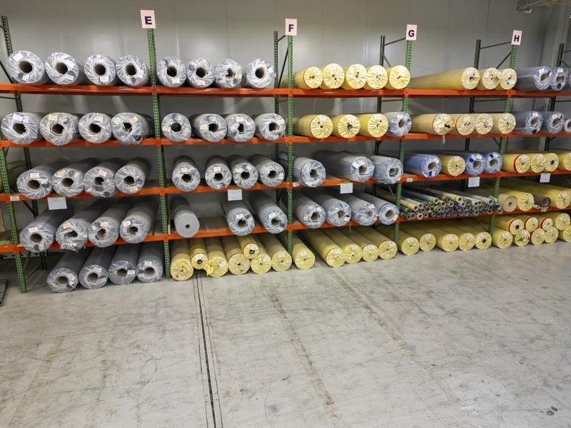Integra Aegis fabric roll storage — dozens of rolls in multiple colors at manufacturing facility
